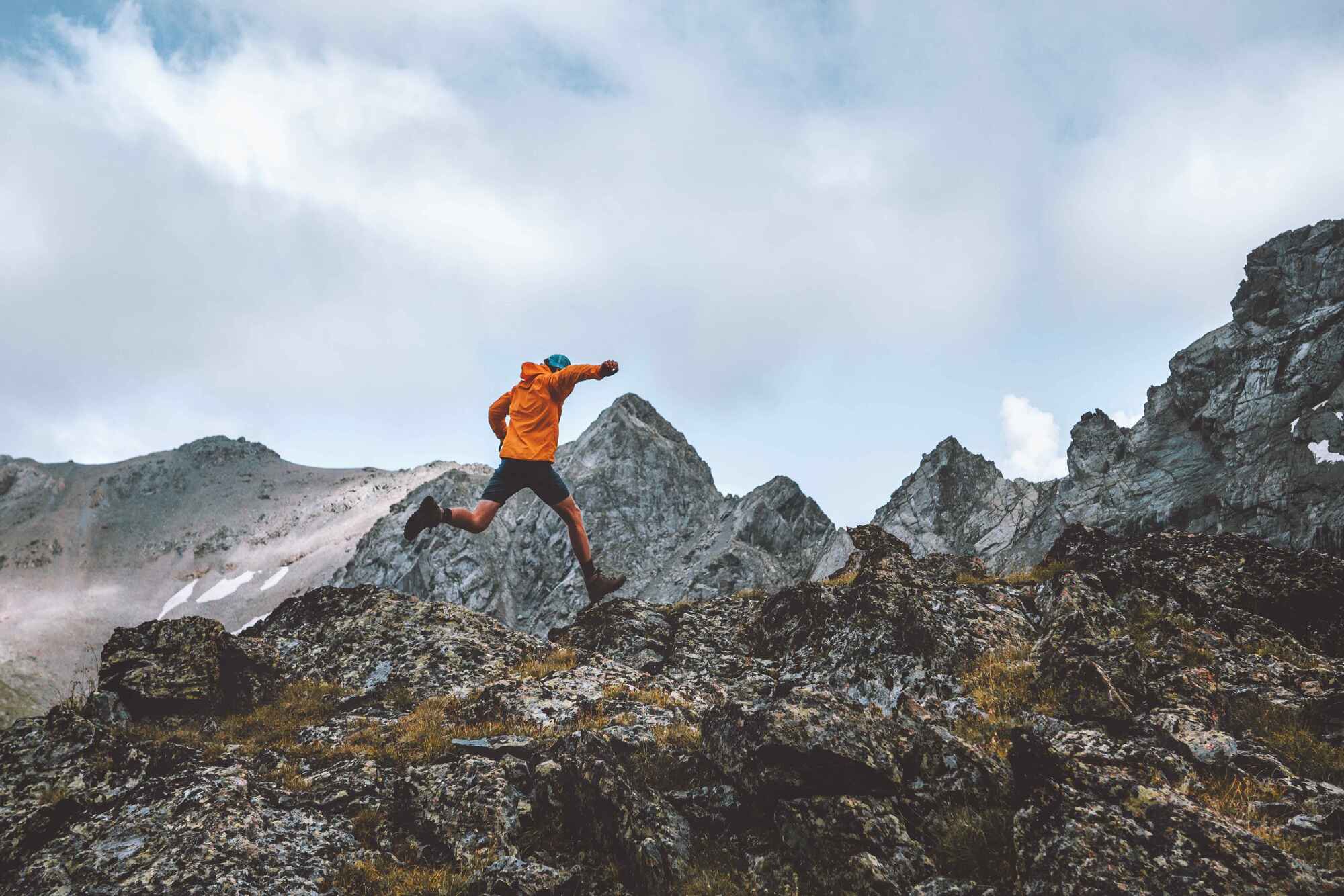 Man running over craggy rocks in the mountains