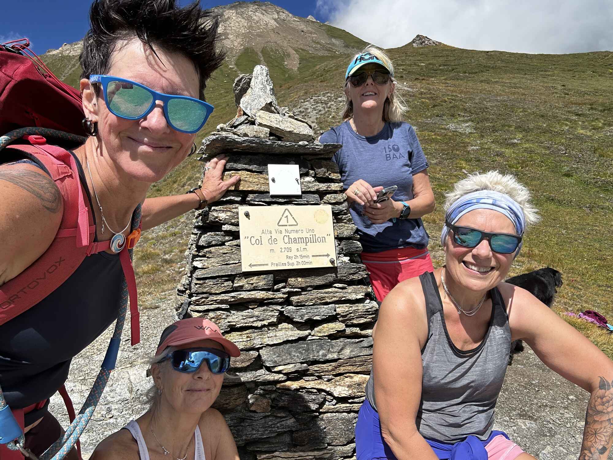 Image of 4 women around the stone stack marking the Col de Champillon