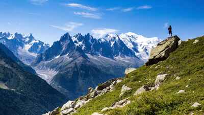 A hiker stood on a rock on the Tour du Mont Blanc